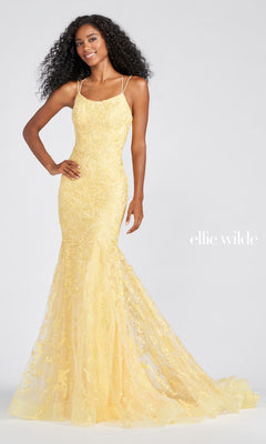 A woman poses in a Long Lace Mermaid Prom Dress with Strappy Back by ellie wilde, featuring a fitted, floor-length yellow lace design, thin straps, and a flared mermaid hem against a plain background.