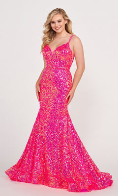 A woman smiles while wearing the Ellie Wilde Long Stretch-Sequin Prom Dress with thin straps and a flared hem, standing against a plain light background.