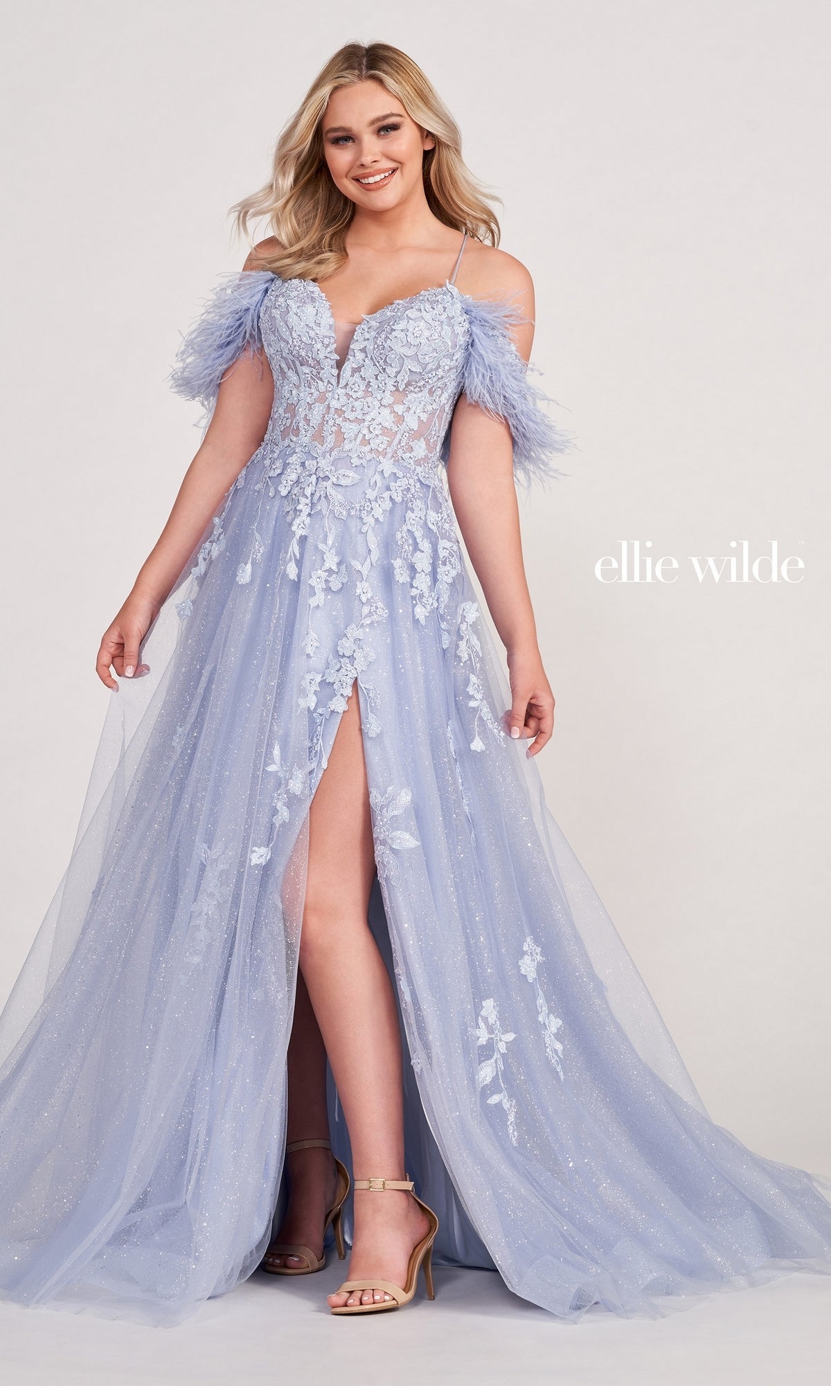A woman wears the Glitter Ball Gown with off-the-shoulder feather sleeves, a sheer bodice, floral appliqué, and thigh-high slit. The light blue dress is shown on a white background with 