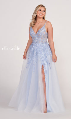 A woman wears the Glitter-Tulle Long Ellie Wilde Prom Dress EW34089, featuring a light blue sleeveless design with embroidered lace, floral appliqué, deep V-neckline, and high slit against a plain backdrop.