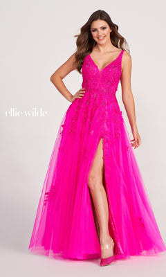A woman poses confidently in the Ellie Wilde Side-Slit Long Prom Ball Gown EW34103, featuring a bright pink hue, sleeveless design, floral lace details, deep V-neckline, and a high slit.