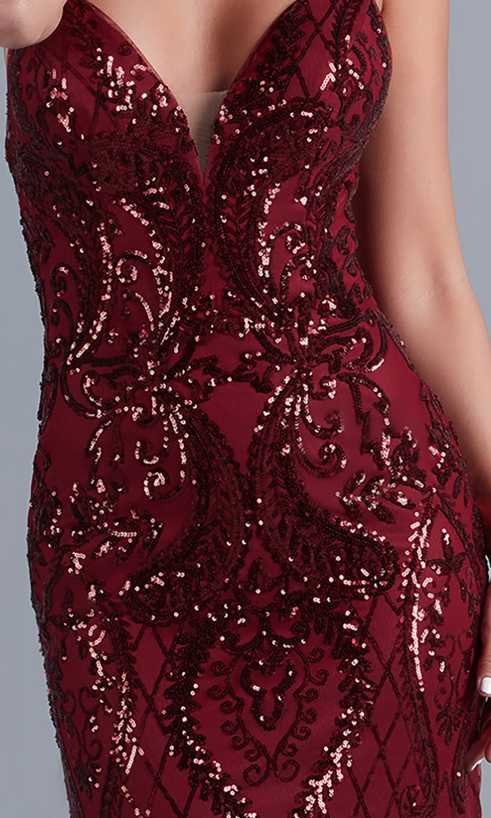 A woman wearing a fitted, sleeveless burgundy Backless PromGirl Long Prom Dress in sequin tulle with intricate embroidery and a deep neckline.