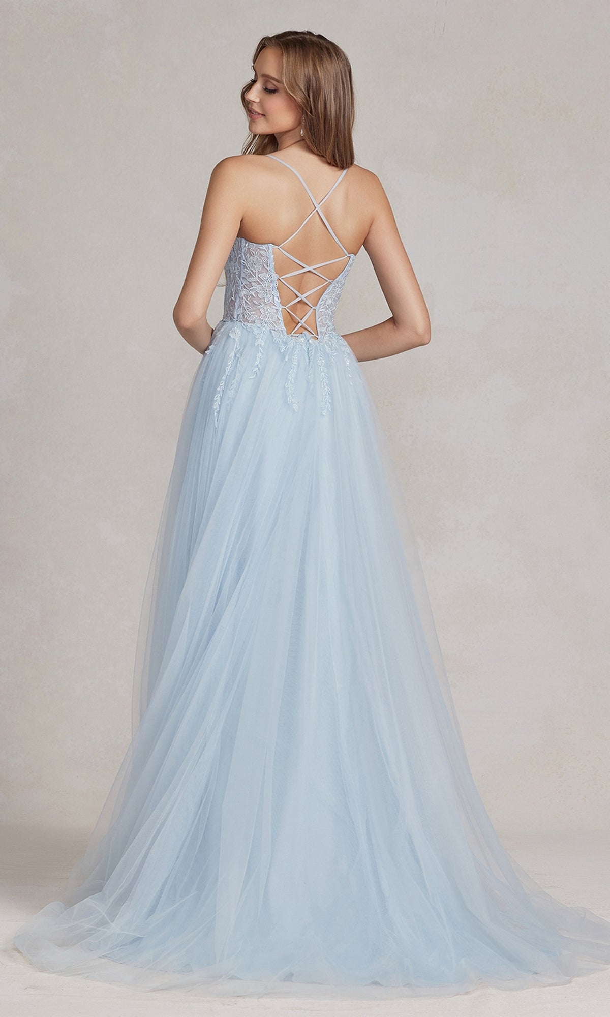A woman wears the Corset-Bodice Long Pastel Prom Dress, featuring a sheer-lace corset bodice, thin straps, a lace-up back, and a floor-length skirt as she stands facing away from the camera.