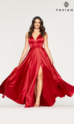 A woman models the Long Faviana Prom Dress, featuring a sleeveless red charmeuse design with a V-neckline, thigh-high slit, and back cut out. The "Faviana" brand name is displayed in the top right corner against a plain background.