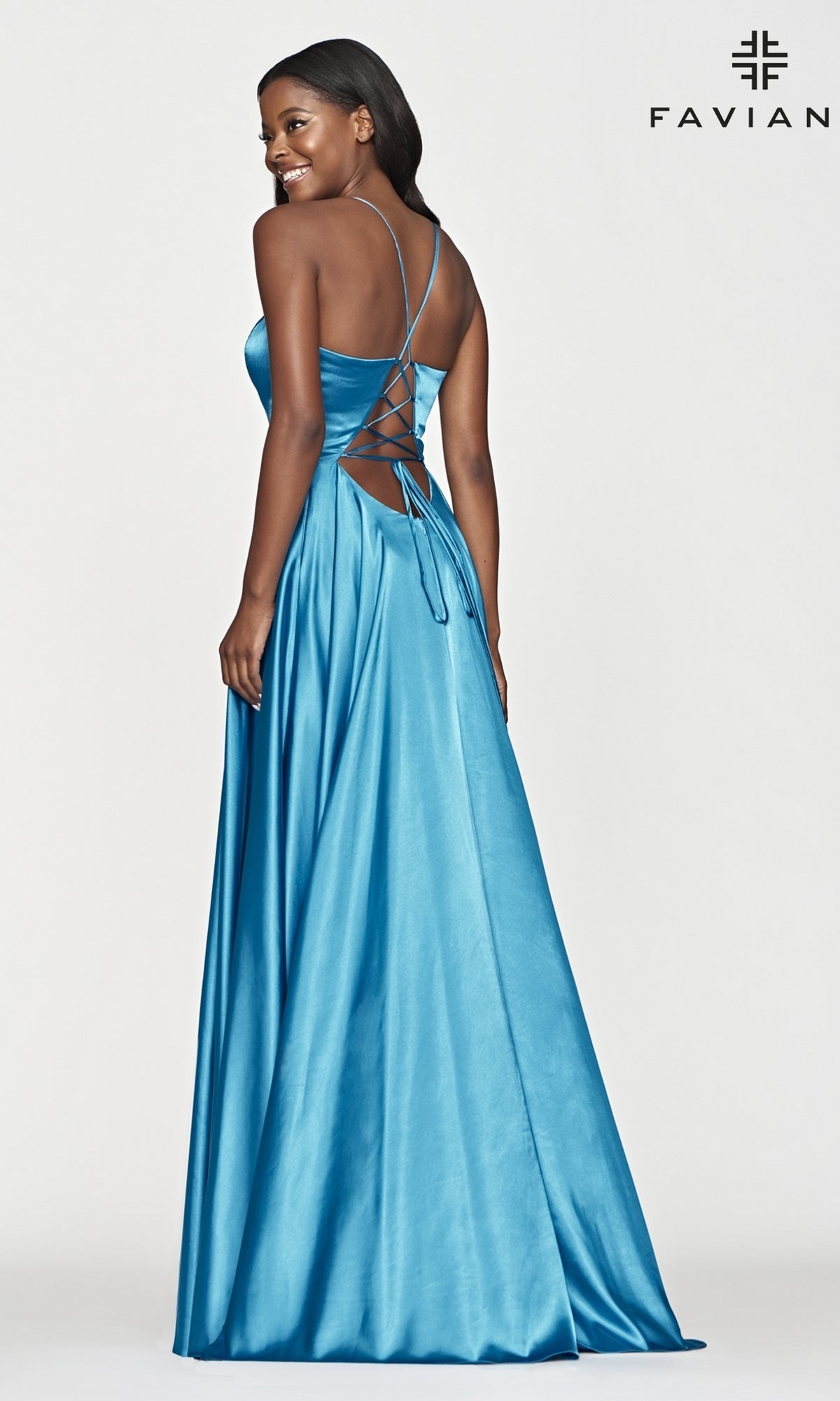 A woman stands looking over her shoulder in a Long Faviana Prom Dress featuring satin charmeuse fabric and a lace-up back, with the 