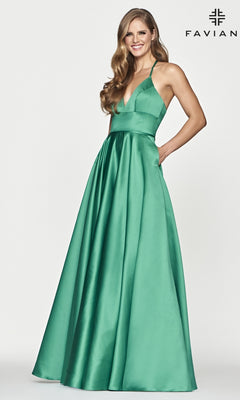 A woman wears the Corset-Back A-Line Long Satin Prom Dress by Faviana—sleeveless, emerald green satin with a deep V-neckline and pockets—standing against a plain white background. "FAVIANA" is in the top right corner.