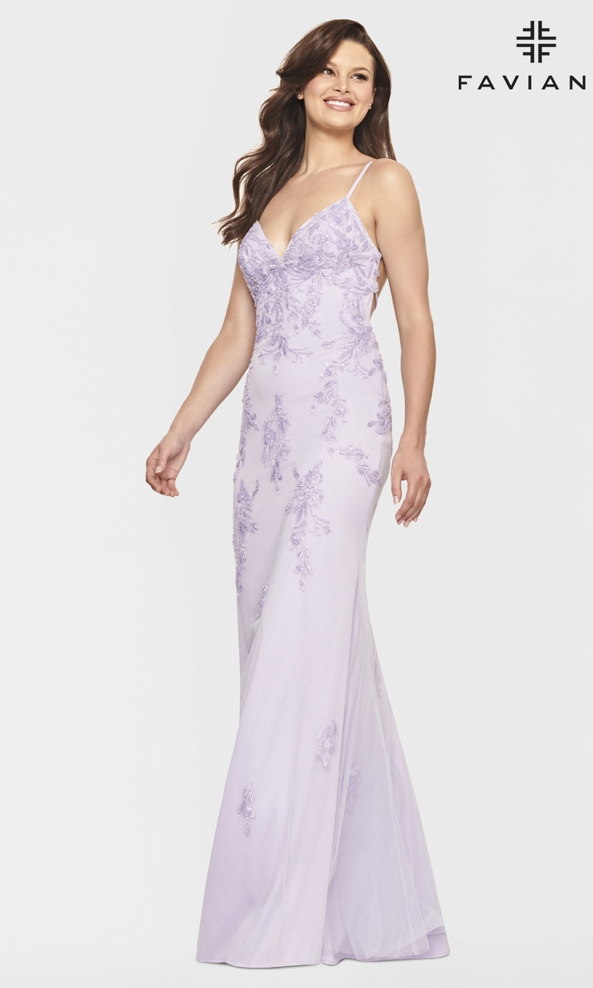 A woman stands smiling against a plain white background, wearing a Strappy-Back Long Light Pink Prom Dress by Faviana with thin straps and a V-neckline.