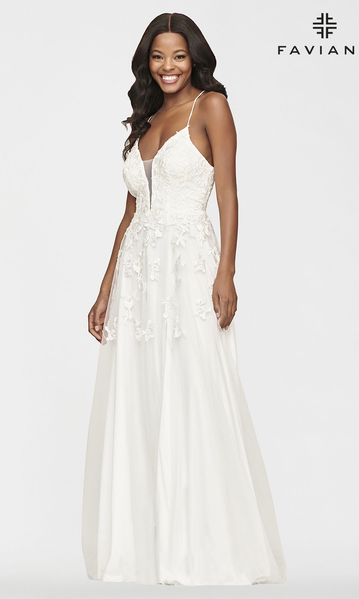 A woman smiles against a plain background wearing the Faviana Embroidered A-Line Long Prom Dress, a white sleeveless gown with 3-D floral embroidery. 