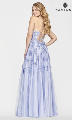 Woman in a Faviana Embroidered A-Line Long Prom Dress with 3-D floral embroidery and lace-up back stands, looking over her shoulder.