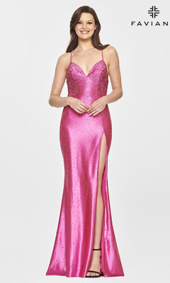 A woman wears the Long Stretch-Satin Beaded Prom Dress by Faviana—this sleeveless, floor-length bright pink gown features a thigh-high slit and dazzling beaded embellishments, as she stands smiling against a plain background.