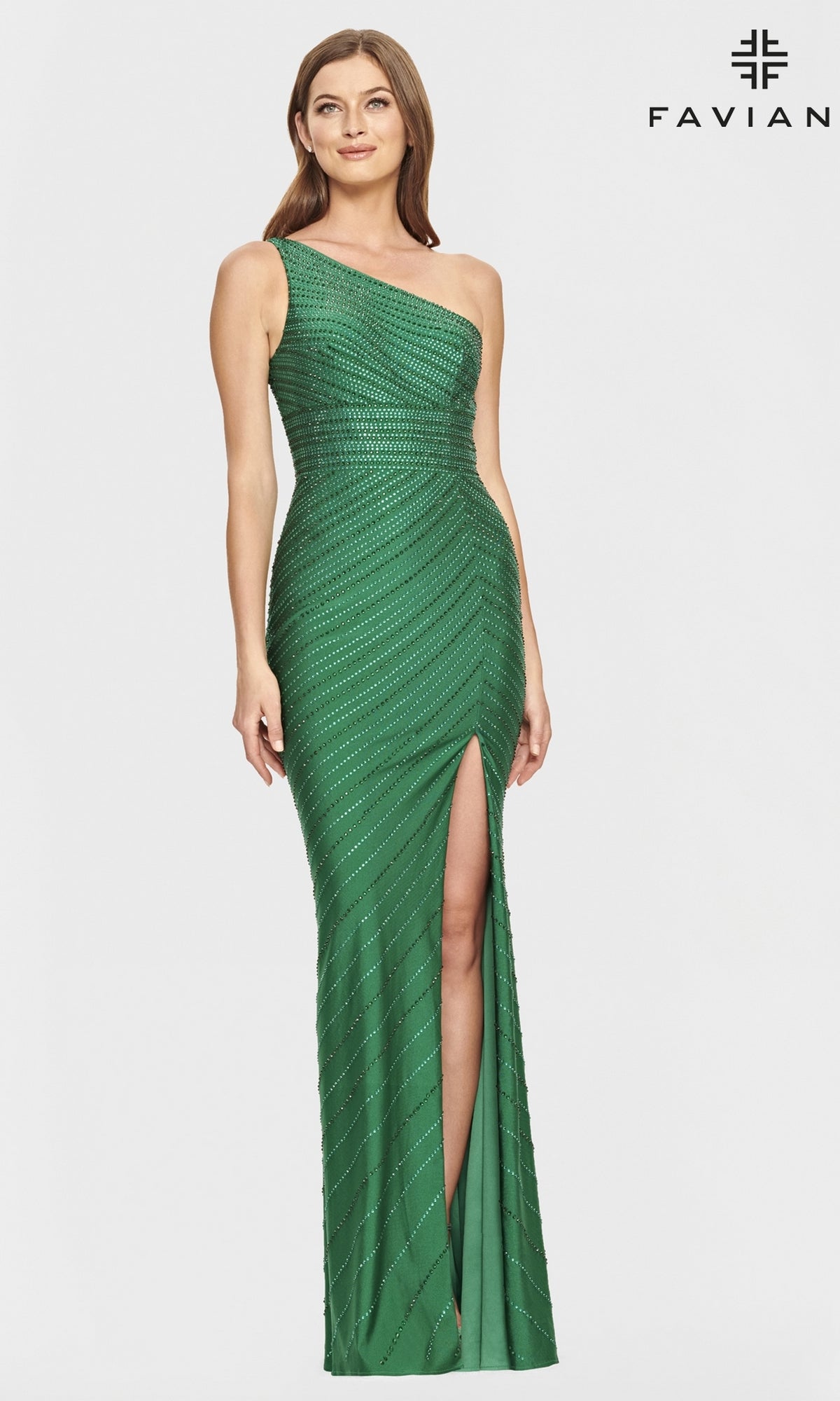 A woman stands against a white background wearing the One-Shoulder Beaded Long Prom Dress by Faviana—a green gown with a thigh-high slit, diagonal embellishments, and one-shoulder design. The 