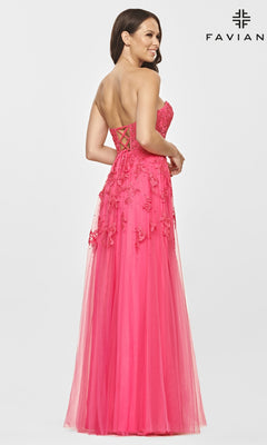 Woman in a Faviana Strapless Sweetheart Long Lace Prom Dress, bright pink with floral appliqué and lace-up back, stands against a plain white background.