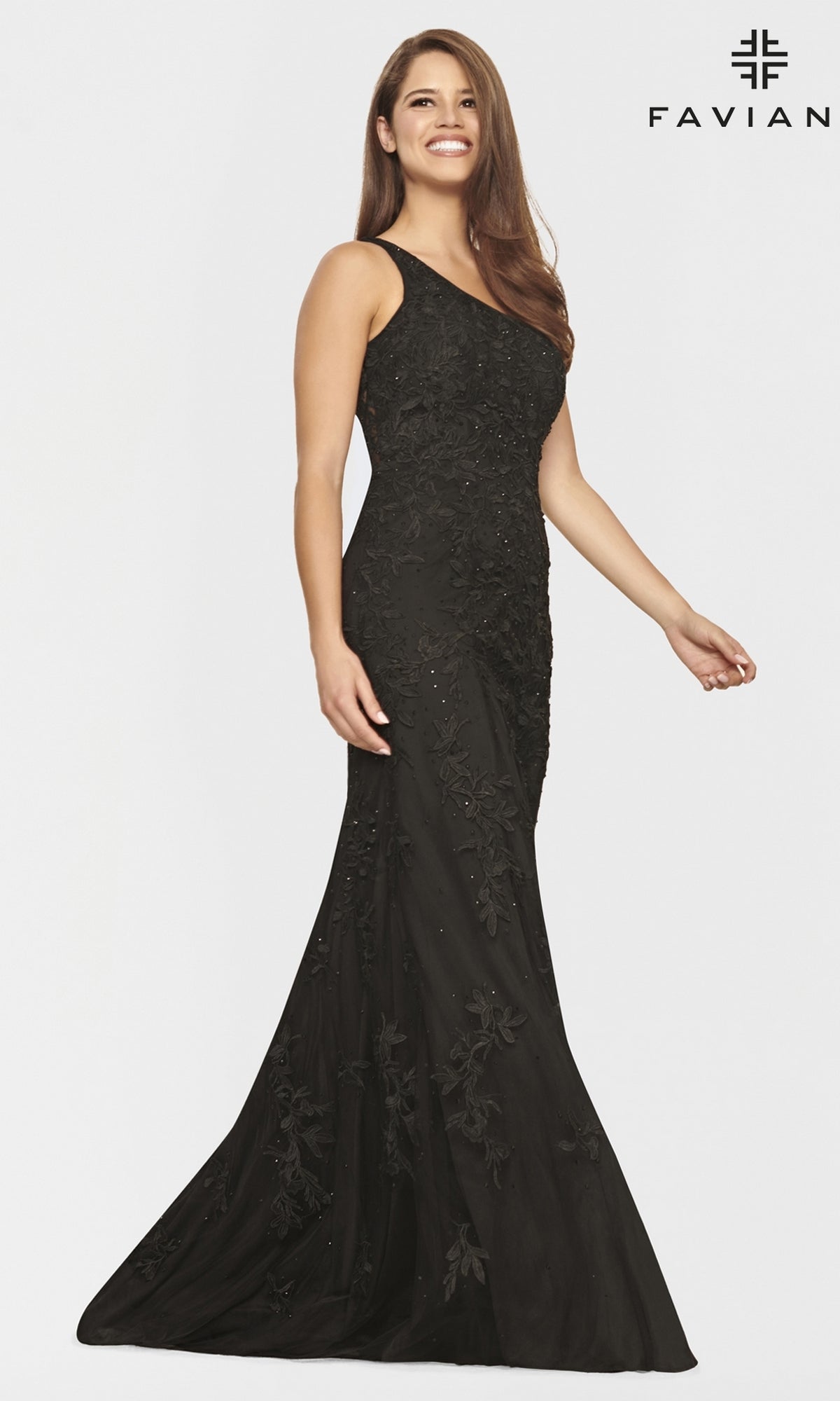 A woman stands and smiles against a plain white background, wearing a fitted One-Shoulder Faviana Long Lace Formal Dress with floral embroidery.