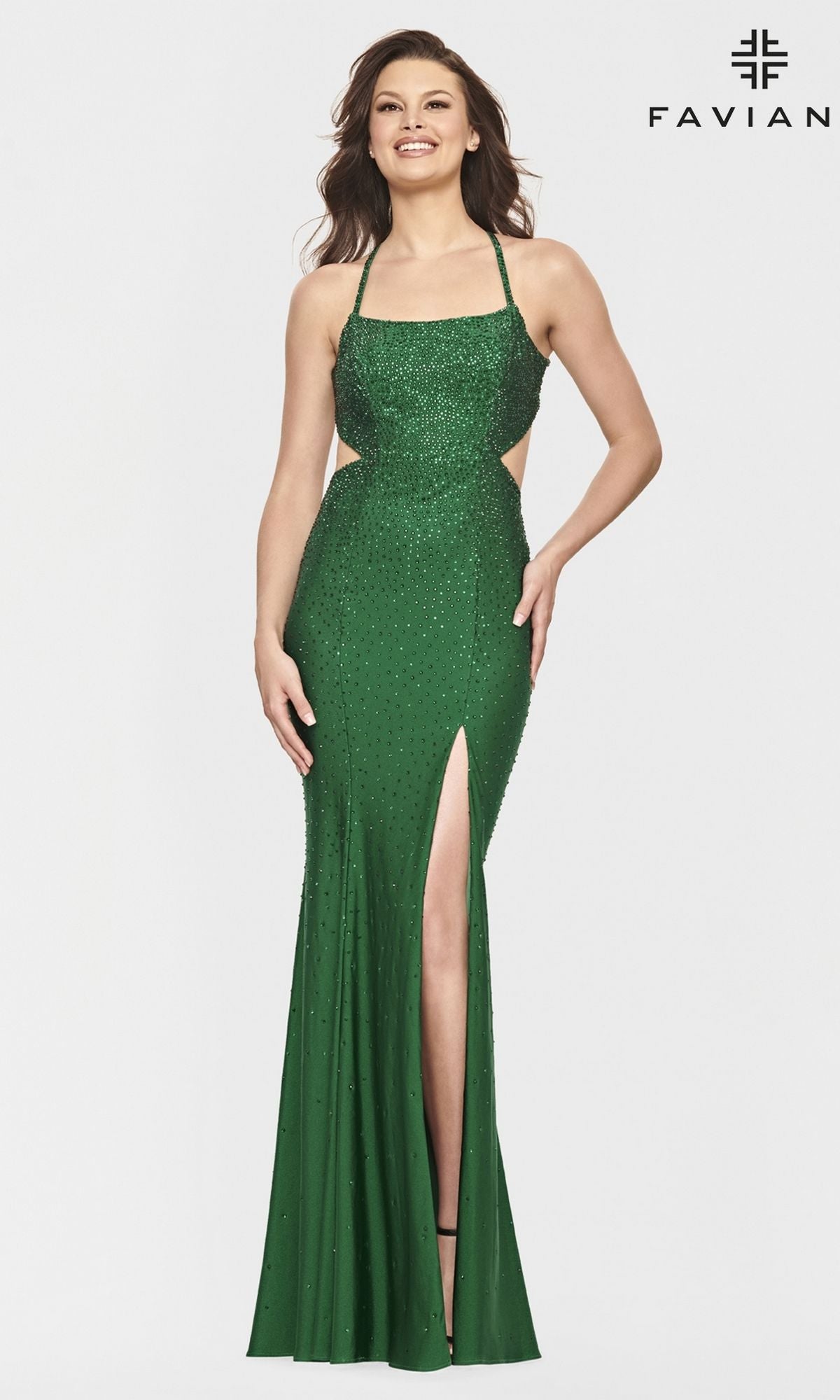 A woman smiles on a white background, wearing the Open-Back Beaded Long Faviana Prom Dress S10829—floor-length, sleeveless, with a thigh-high slit and beaded details. 