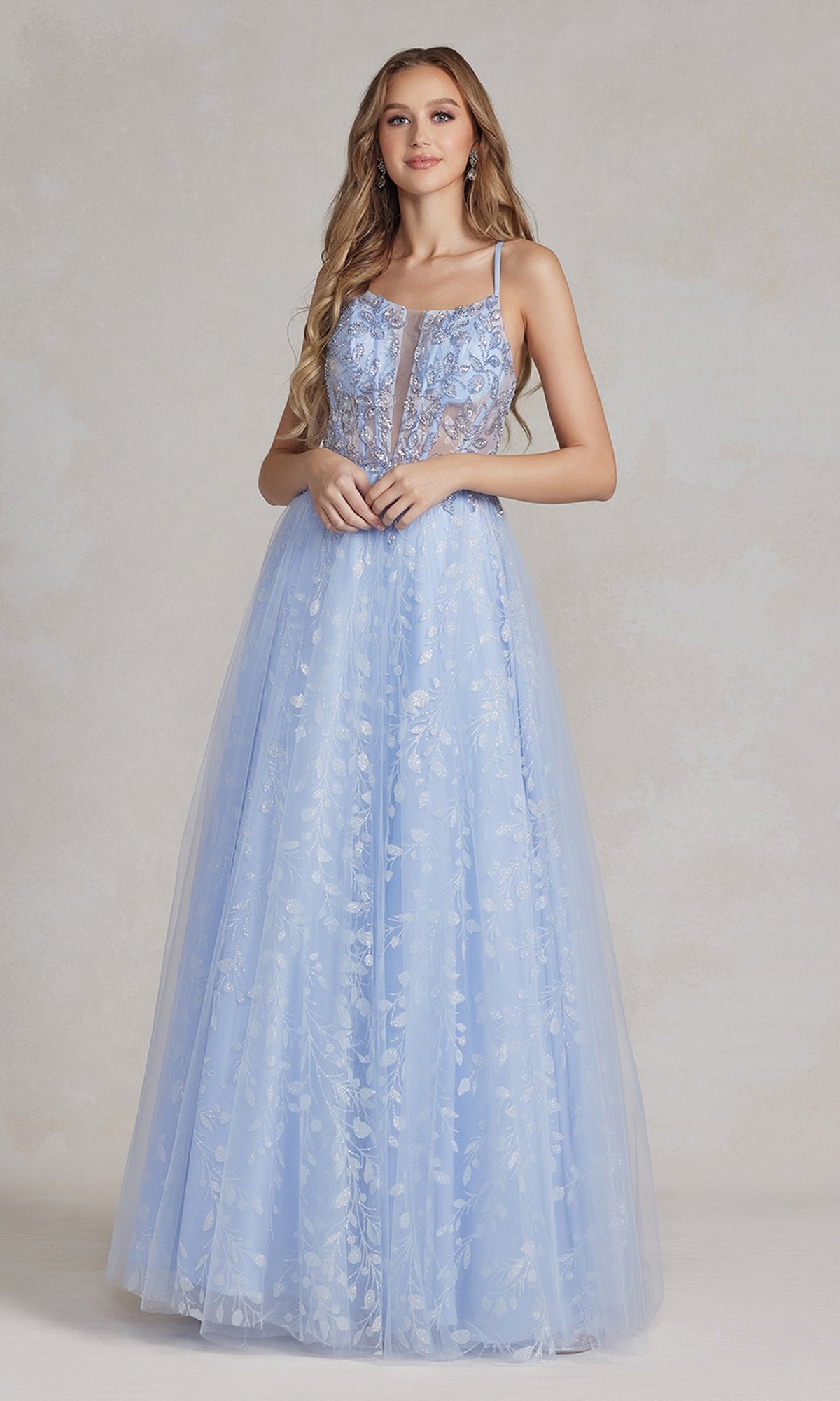 A woman wearing the Periwinkle Illusion-Bodice Long Prom Dress with floral embroidery and a sheer panel stands against a neutral background.