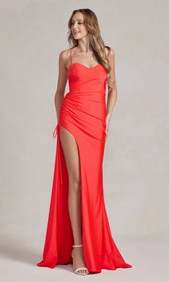 A woman stands against a neutral background wearing the Strappy-Back Affordable Long Prom Dress in bright red, featuring spaghetti straps, a thigh-high slit, and ruched detailing.