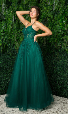 A woman stands on a tiled surface before lush green foliage, wearing the Long Embroidered Sheer-Corset Prom Ball Gown—a sleeveless, floor-length formal dress in green.