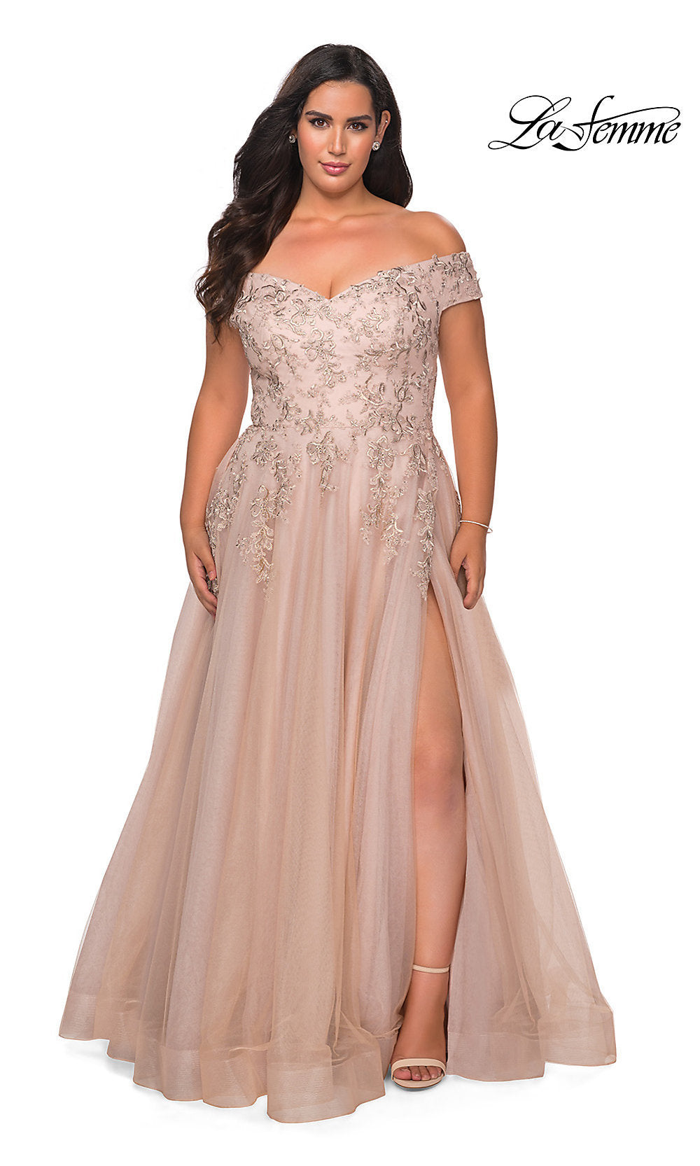 A woman wears the Off-the-Shoulder Plus-Size La Femme Prom Ball Gown in blush pink, featuring beaded embroidery, a fitted bodice, tulle skirt with thigh-high slit. The 