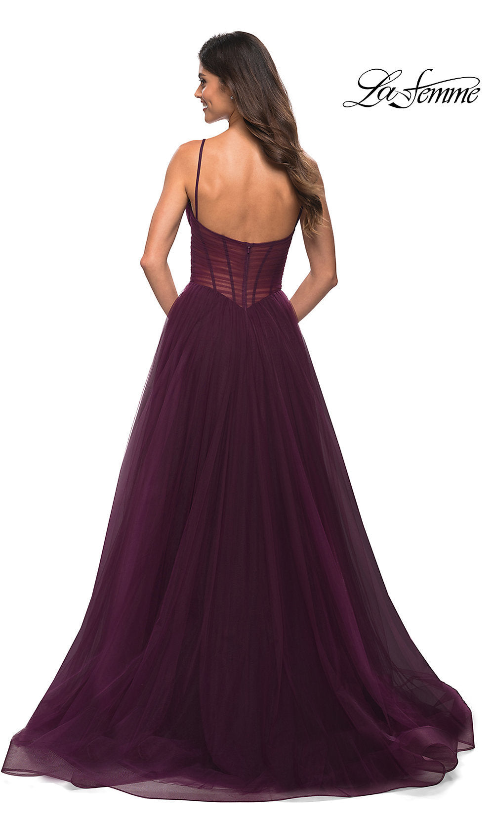 A woman faces away, wearing the Long La Femme Prom Dress with Sheer Corset Waist—floor-length and dark purple, featuring a fitted bodice and thin straps. The La Femme logo is in the top right corner.