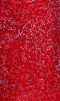 Close-up of the Ellie Wilde Beaded Mermaid Prom Dress with Cut Out, showing red fabric adorned with small, shiny sequins that create a sparkling, reflective surface.