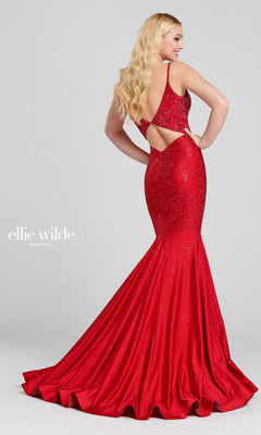 A woman poses in the Ellie Wilde Beaded Mermaid Prom Dress with Cut Out, featuring sparkling embellishments and a fitted mermaid silhouette, against a plain light background for an elegant look.