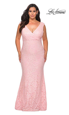 A woman wears an empire-waist, long plus-size prom dress by La Femme in light pink sequin-lace. The sleeveless, V-neck gown features a fitted silhouette with subtle floral patterns. The "La Femme" logo appears in the top right corner.