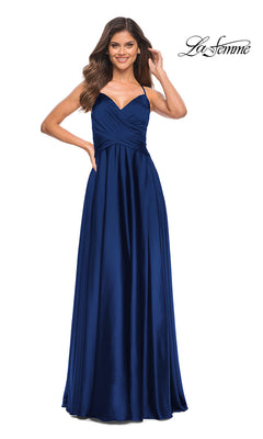 A woman stands smiling in a floor-length, sleeveless dark blue La Femme Lace-Up Back Long Satin A-Line Prom Dress with a sweetheart neckline.