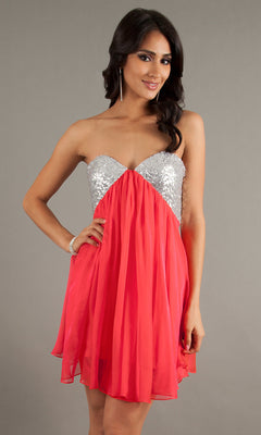A woman models the Strapless Short Chiffon Hoco Dress: La Femme 17649, featuring a sequin sweetheart bodice and flowing red skirt, against a plain gray background.